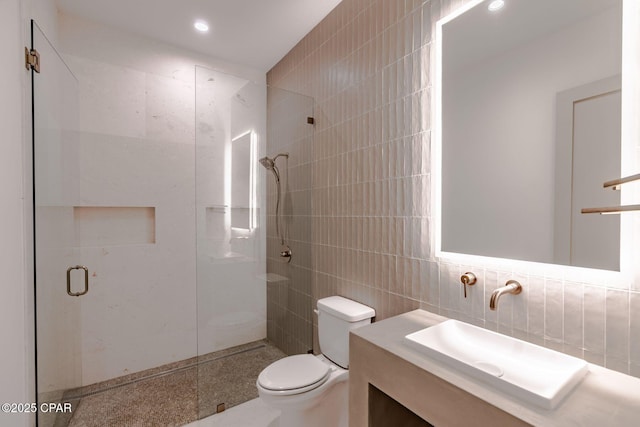 bathroom featuring toilet, vanity, a shower stall, tile walls, and recessed lighting