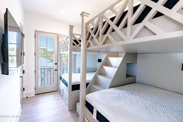 bedroom with light wood-style floors and access to outside