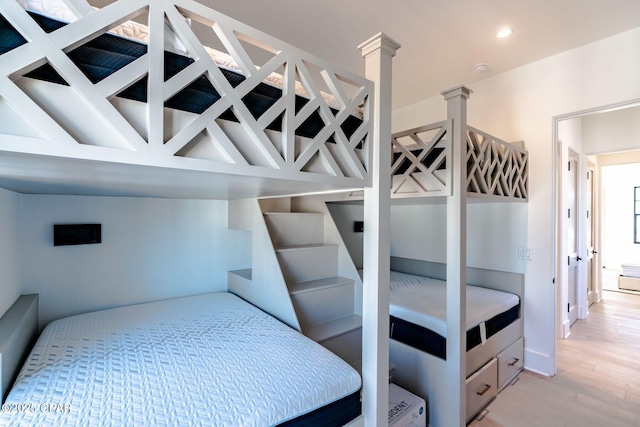 bedroom featuring light wood-style floors, ornate columns, and recessed lighting