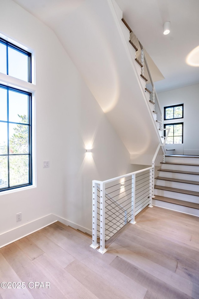 stairs with wood finished floors and baseboards