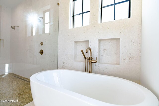 full bath featuring a freestanding tub and walk in shower