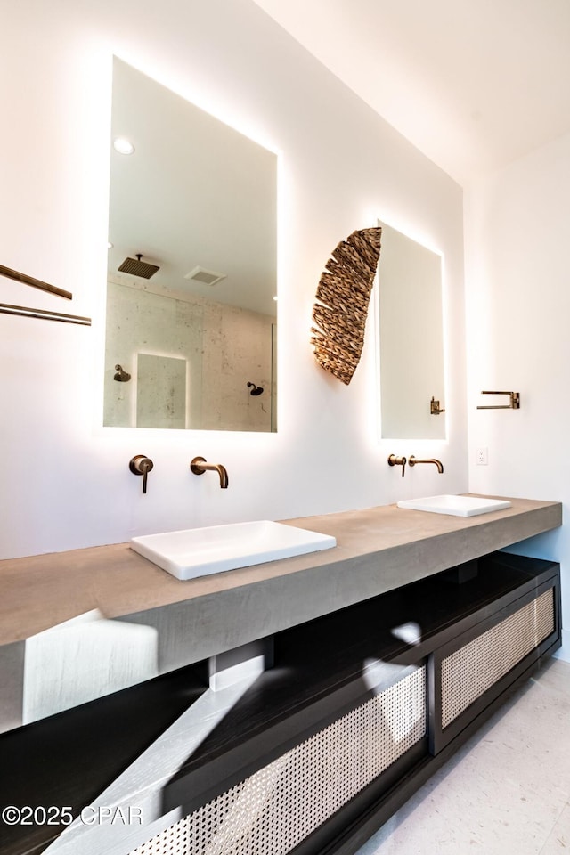 bathroom with double vanity, visible vents, a sink, and a walk in shower