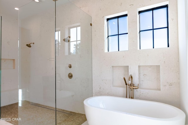 bathroom featuring a freestanding bath, walk in shower, and recessed lighting