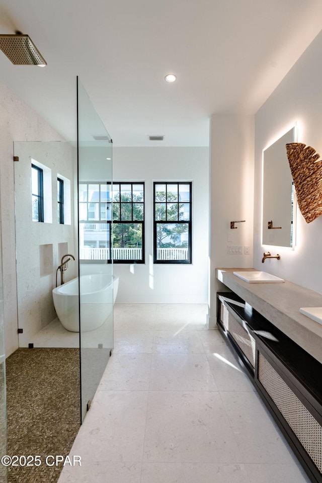 full bathroom featuring double vanity, a soaking tub, visible vents, and a sink