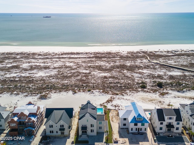 drone / aerial view with a residential view, a water view, and a beach view