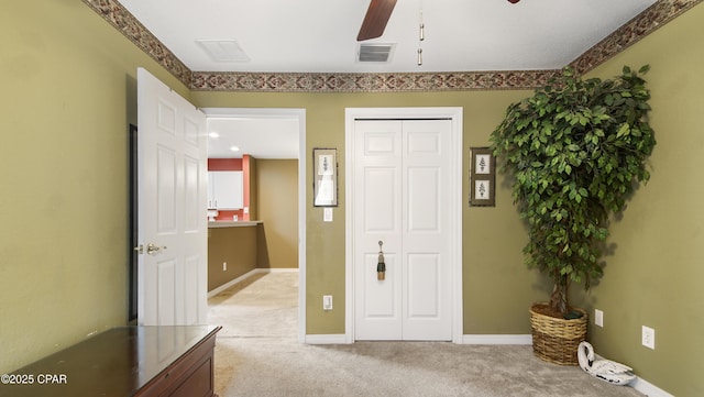 foyer featuring visible vents, baseboards, light colored carpet, and a ceiling fan