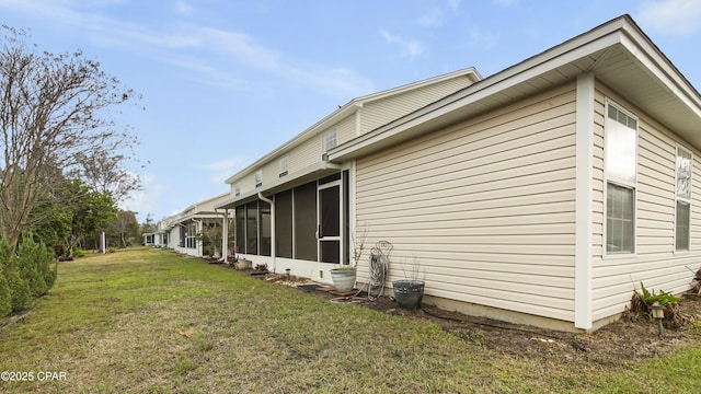 view of side of home featuring a lawn and a sunroom