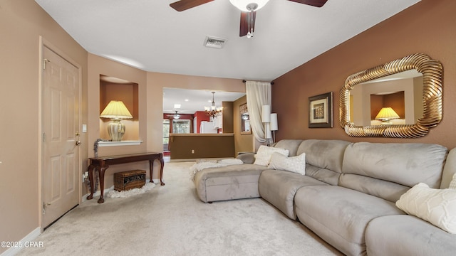 carpeted living area with visible vents, baseboards, and ceiling fan with notable chandelier