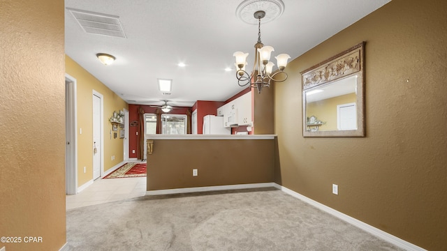 unfurnished dining area featuring visible vents, baseboards, light colored carpet, and ceiling fan with notable chandelier