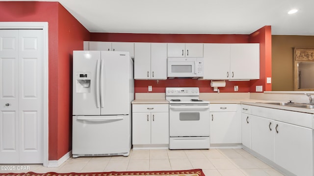 kitchen featuring white cabinetry, white appliances, light countertops, and a sink