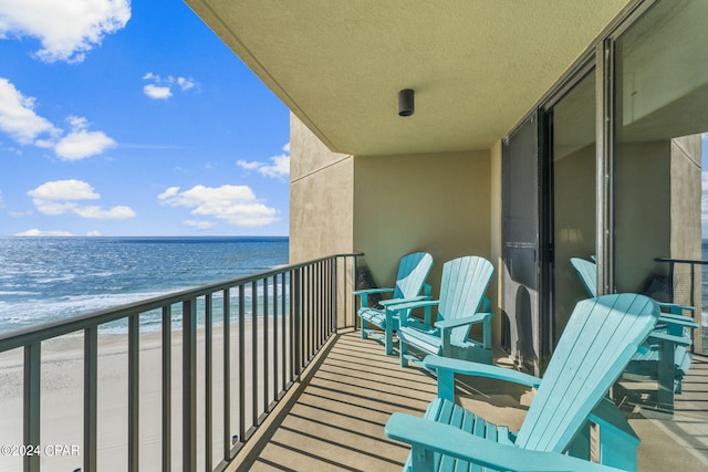 balcony featuring a water view and a view of the beach