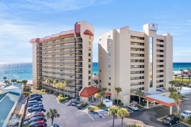 view of building exterior featuring a water view and uncovered parking