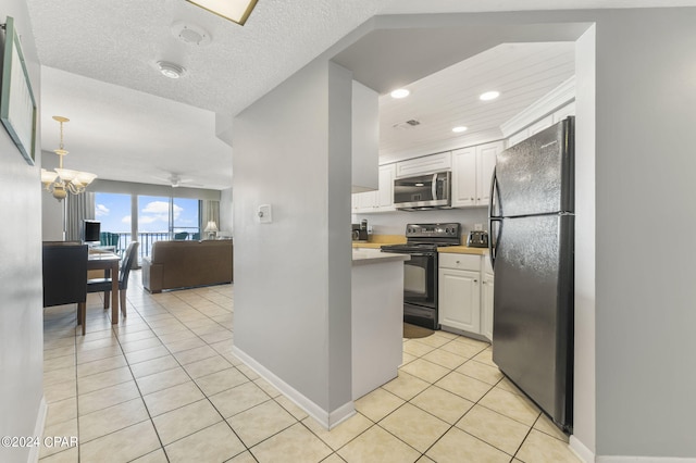 kitchen featuring light tile patterned floors, black appliances, open floor plan, and white cabinetry