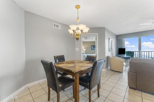 dining area with light tile patterned floors, visible vents, baseboards, and ceiling fan with notable chandelier