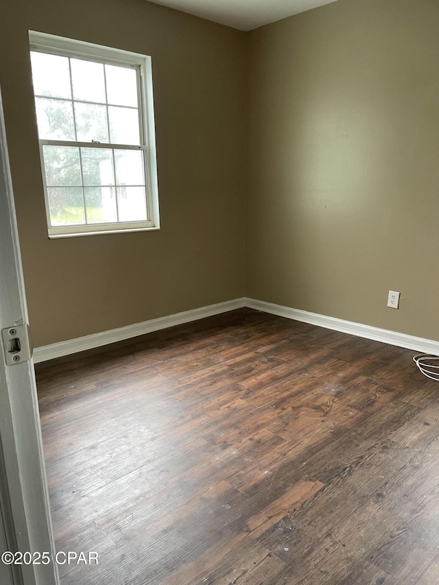 empty room featuring dark wood-style flooring and baseboards