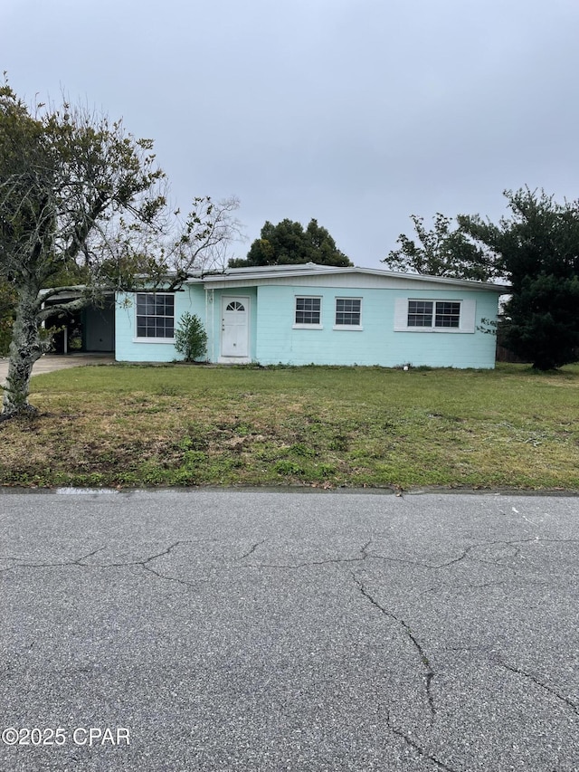 view of front of property with a carport and a front lawn