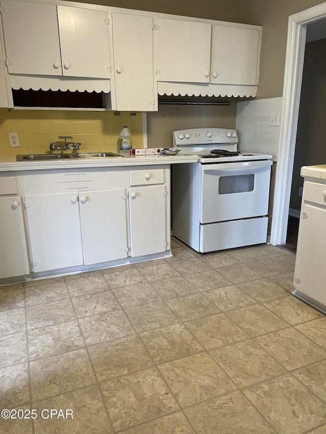 kitchen with white electric stove, a sink, white cabinetry, light countertops, and backsplash