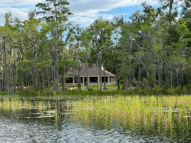 view of dock with a water view and a wooded view