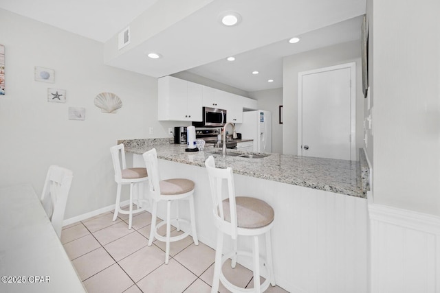 520 Richard Jackson Blvd Unit 3308, Panama City Beach, FL 32407 - kitchen featuring light tile patterned floors, visible vents, a sink, white cabinets, and stainless steel microwave