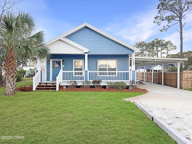 view of front of property with a porch, concrete driveway, fence, a carport, and a front lawn