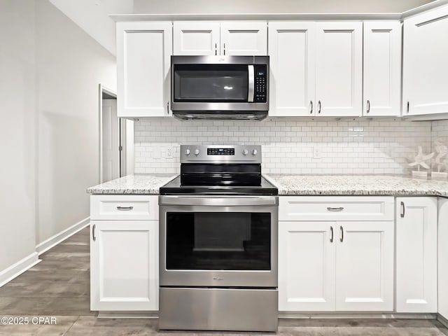 kitchen with stainless steel appliances, decorative backsplash, and white cabinets