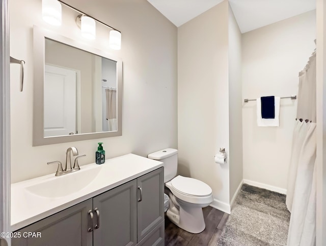 full bathroom with wood finished floors, vanity, toilet, and baseboards