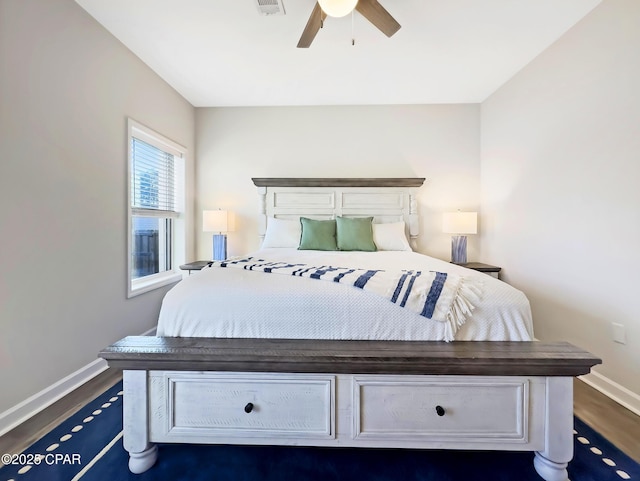 bedroom with ceiling fan, dark wood-type flooring, and baseboards