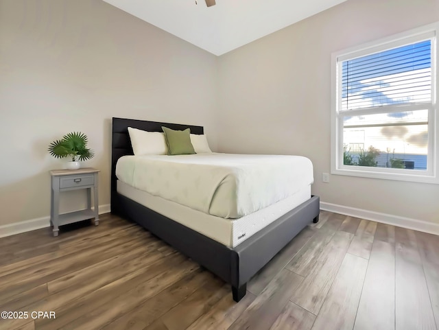 bedroom featuring vaulted ceiling, baseboards, and wood finished floors