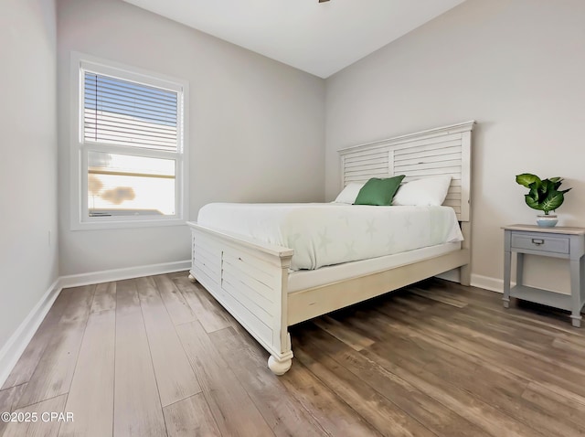 bedroom featuring wood finished floors and baseboards