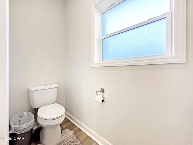 bathroom featuring wood finished floors, toilet, and baseboards