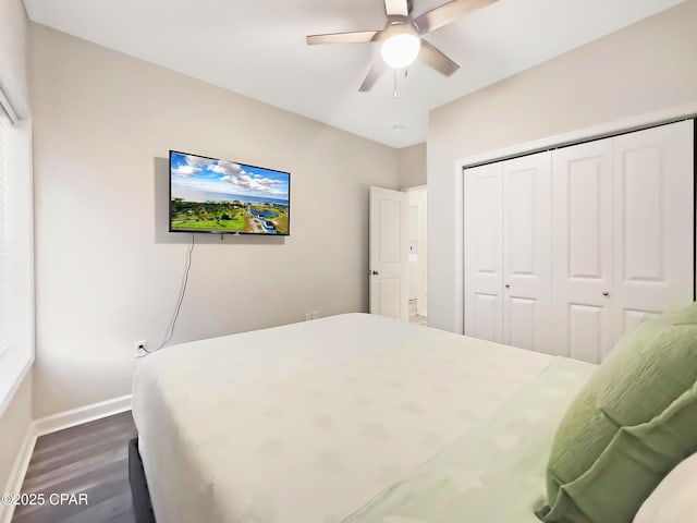 bedroom featuring a ceiling fan, baseboards, dark wood-type flooring, and a closet