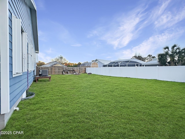 view of yard featuring a fenced backyard and central AC