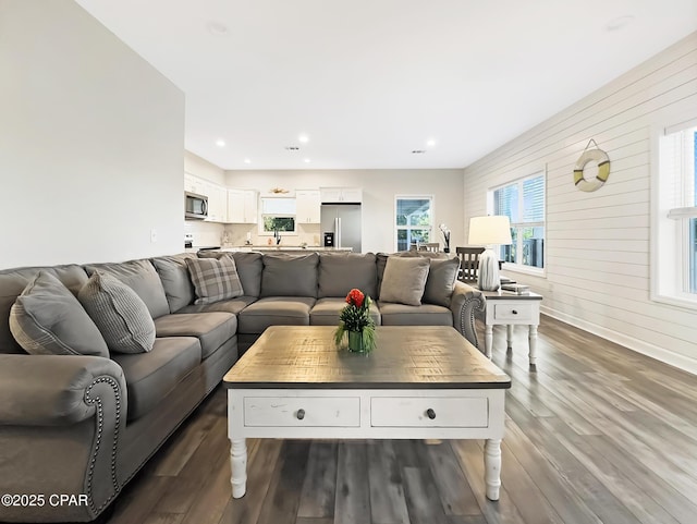 living area with wood walls, dark wood finished floors, a wealth of natural light, and recessed lighting