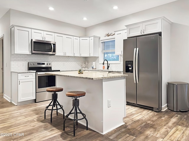 kitchen featuring light wood-type flooring, stainless steel appliances, and a center island