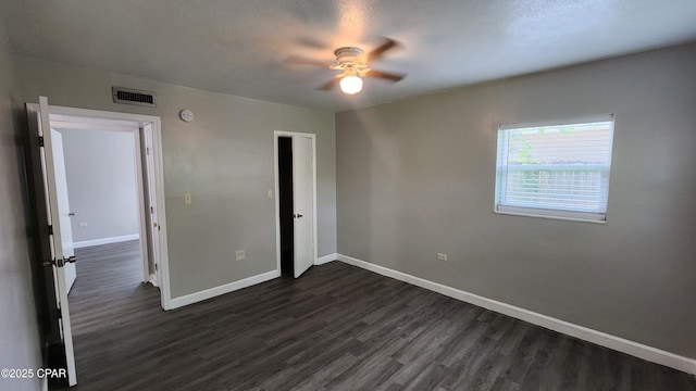 unfurnished bedroom with visible vents, a ceiling fan, dark wood finished floors, a closet, and baseboards