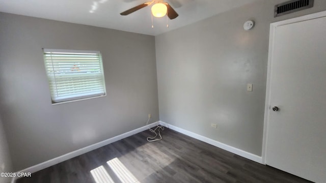 empty room with visible vents, baseboards, dark wood-type flooring, and ceiling fan