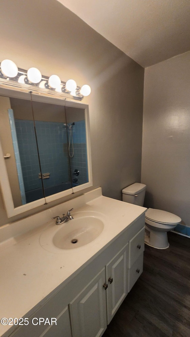 bathroom with toilet, wood finished floors, and vanity
