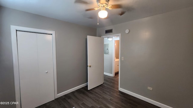 unfurnished bedroom with visible vents, electric panel, dark wood-style floors, a closet, and baseboards