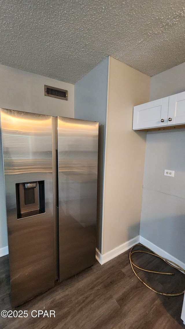 kitchen featuring visible vents, baseboards, dark wood-style flooring, white cabinets, and stainless steel refrigerator with ice dispenser