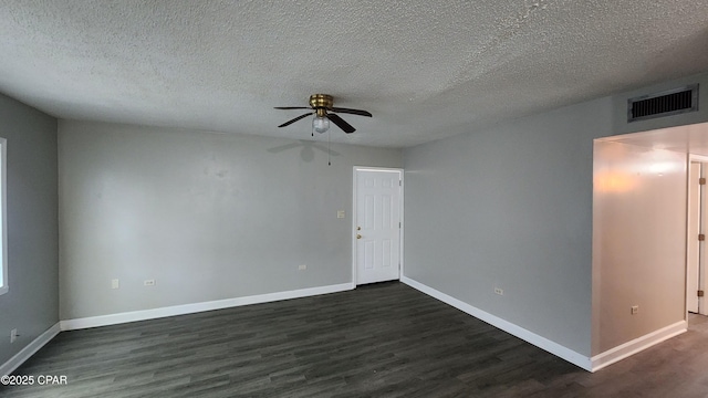 spare room featuring a ceiling fan, visible vents, baseboards, dark wood finished floors, and a textured ceiling