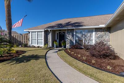 ranch-style house with stone siding, fence, and a front lawn