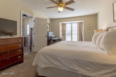 bedroom featuring carpet floors, a textured ceiling, and a ceiling fan