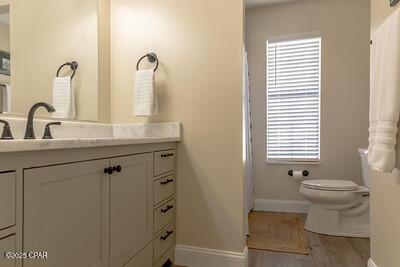 full bathroom with toilet, baseboards, wood finished floors, and vanity