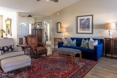 living area with lofted ceiling, ceiling fan, and wood finished floors