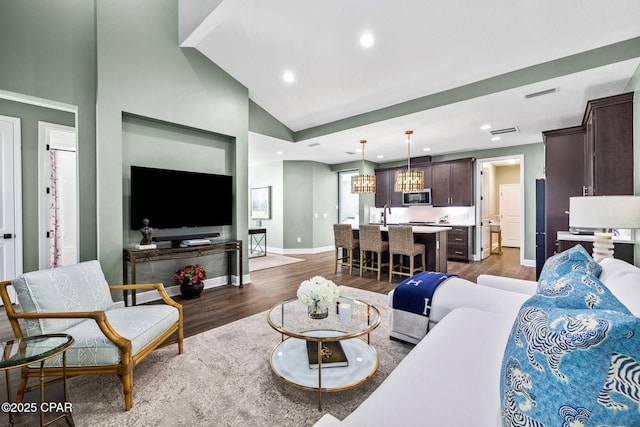 living room with visible vents, baseboards, lofted ceiling, recessed lighting, and dark wood-type flooring