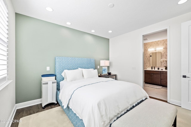 bedroom with recessed lighting, baseboards, wood finished floors, and ensuite bath