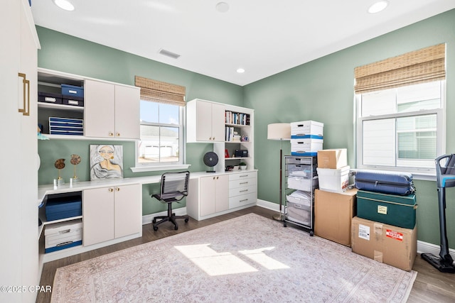 office space featuring baseboards, recessed lighting, wood finished floors, and visible vents