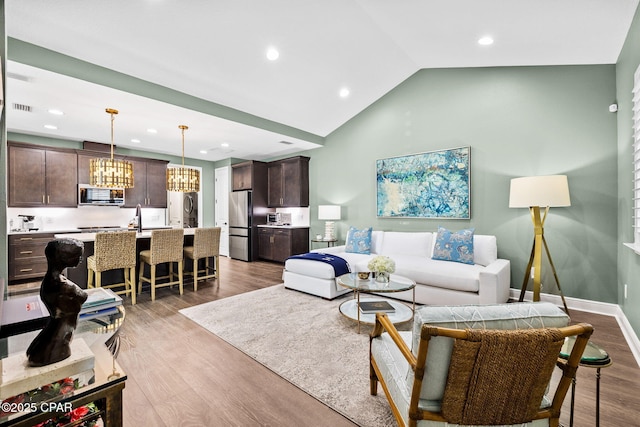 living room featuring an inviting chandelier, recessed lighting, light wood finished floors, and visible vents