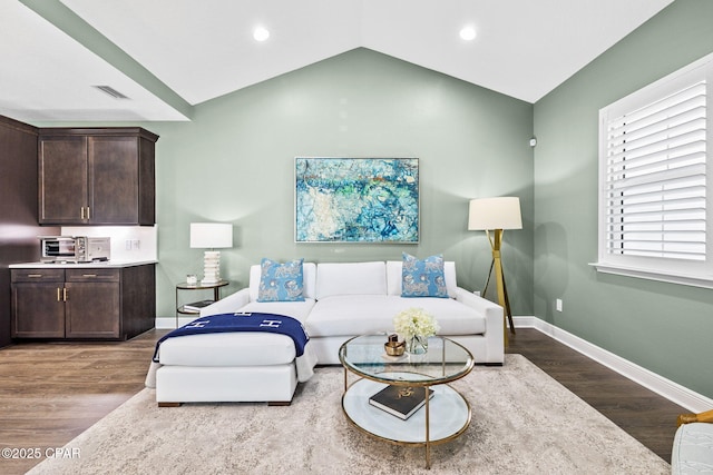 living room with visible vents, wood finished floors, baseboards, recessed lighting, and vaulted ceiling