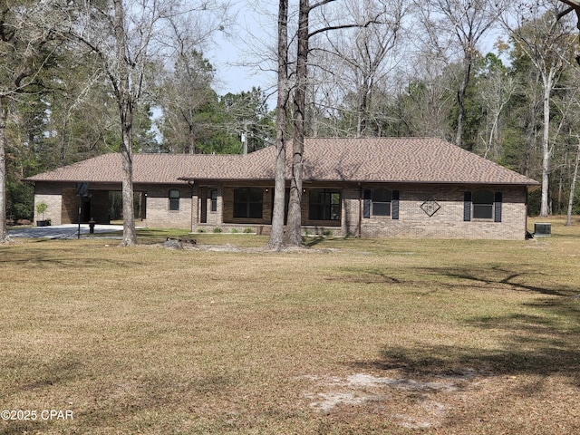 view of front of home featuring a front lawn, roof with shingles, and brick siding